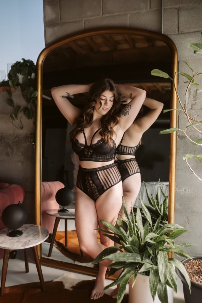 client poses against mirror during facebook live boudoir session