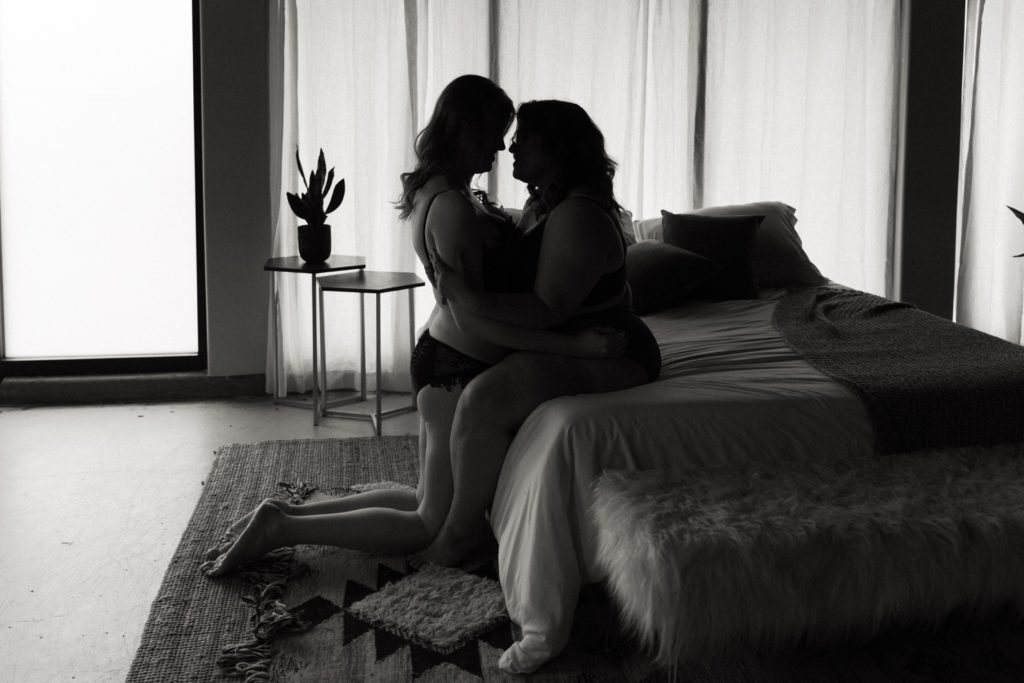Couples boudoir session cuddled on edge of bed