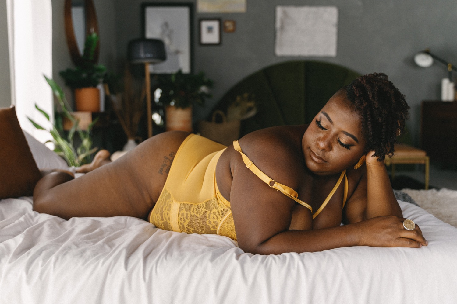 Good Bodies Client on bed in yellow bodysuit